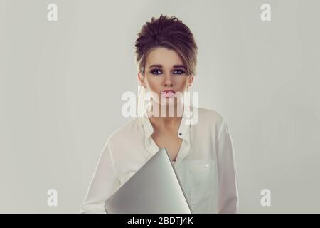 Happy student. Closeup portrait head shot professional beautiful confident young business woman holding computer isolated white studio wall background