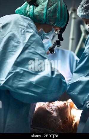 In the hospital operating room. An international team of professional surgeons and assistants works in a modern operating room. Professional doctors Stock Photo