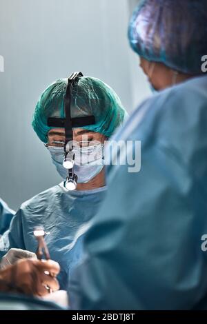 In the hospital operating room. An international team of professional surgeons and assistants works in a modern operating room. Professional doctors Stock Photo