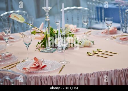 Beautiful table setting on Coral color tablecloth. Ready to serve lunch Stock Photo