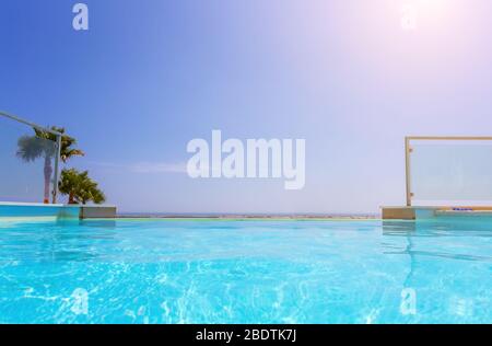 Luxury swimming pool and blue water at the resort with beautiful sea view.  Stock Photo