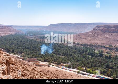 Palm Trees and Smoke at the Ziz Valley in Morocco Stock Photo