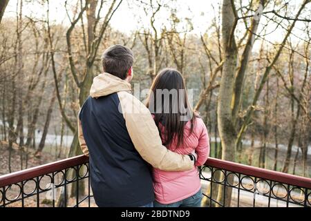 Young loving couple enjoy the sun and warm stroll in the spring park Stock Photo
