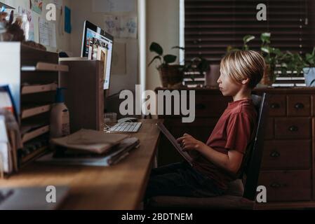 School aged boy learning online by video chat during homeschool Stock Photo