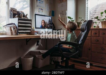 Young boy video chatting with family remotely during isolation Stock Photo