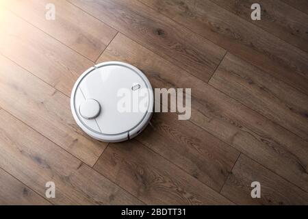 Robot vacuum cleaner on the laminate. View from above. Cleaning in the apartment. Stock Photo