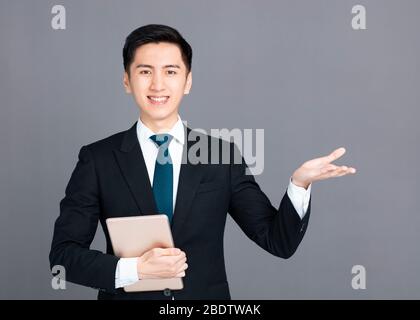 Businessman holding tablet and presenting something in  hand Stock Photo