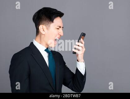 Angry business man screaming on  mobile phone Stock Photo