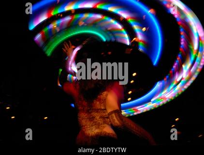 Multi Coloured Hula Hoop Lights Twirled in Circular Motion by Dancer in Lace with Slow Shutter Speed Causing Intentional Blur Photography Stock Photo