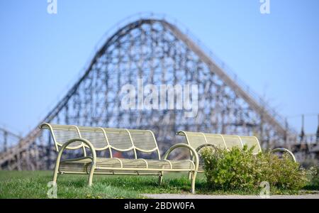 Cleebronn, Germany. 07th Apr, 2020. Empty benches stand in front of the wooden roller coaster 'Mammut' in the empty amusement park Tripsdrill. During the easter holidays the park is actually very well visited. To slow down the spread of the coronavirus, amusement parks are also closed. Credit: Sebastian Gollnow/dpa/Alamy Live News Stock Photo