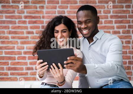 Young Couple Looking At Digital Tablet In Their New Home Stock Photo