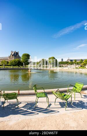 Paris. France - May 15, 2019: Green Chairs next Fountain in Tuileries Garden. Stock Photo