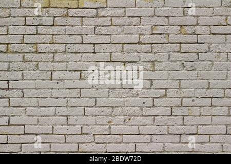 Shabby chic old yellow brick wall texture background, showing a pitted and worn texture from age Stock Photo