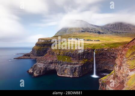 Incredible autumn view of Mulafossur waterfall in Gasadalur village, Vagar Island of the Faroe Islands, Denmark. Landscape photography Stock Photo