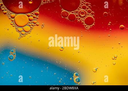 Abstract, image of oil, water and soap in a glass bowl with colourful background Stock Photo
