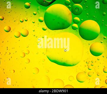 Abstract, image of oil, water and soap in a glass bowl with colourful background Stock Photo