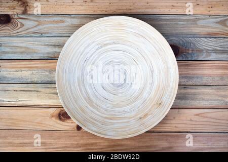 Round bamboo plate on a wooden table closeup. Food photography background Stock Photo