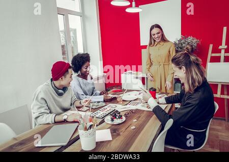 Positive delighted tutor talking to her students Stock Photo