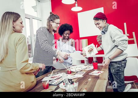 Positive delighted young people visiting art workshop Stock Photo