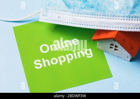 Medical mask, note with text and toy house. Concept on the topic of online shopping during the quarantine period Stock Photo