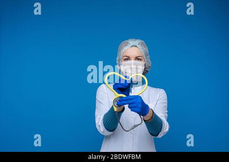 Doctor holding stethoscope in heart shape. Fighting against pandemic concept. Stock Photo