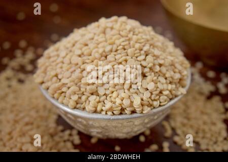 Split White Urad Dal. Vigna mungo Beans  in a Silver bowl on wooden old Table. Rustic style Stock Photo