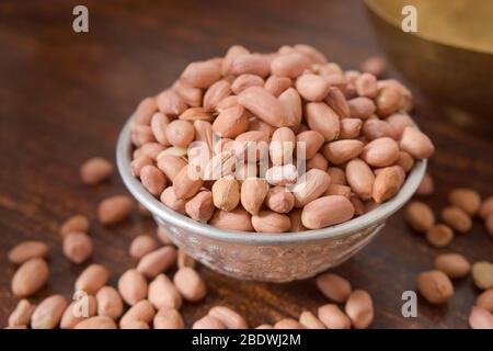 Peeled peanuts in a Silver bowl on wooden old Table. rustic style Stock Photo