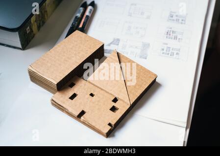 Architect Desk With Cardboard Architectural Model and Hand-drawn Plan Sketches. Selective focus. Stock Photo