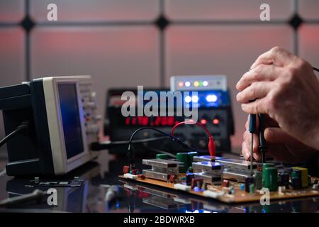 Debugging electronics device. PCB witch microcontroller in electronics laboratory Stock Photo