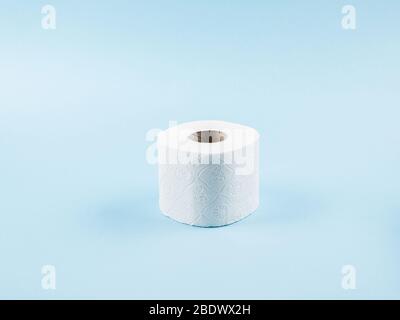 Toilet paper roll on blue backdrop Stock Photo