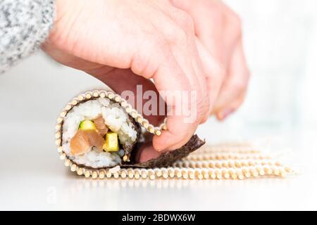 Woman using bamboo rolling mat for home made sushi Stock Photo - Alamy