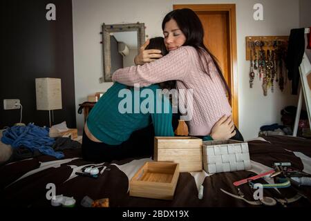 Mother giving daughter a cuddle during Covid19 confinement in Catalonia, Spain Stock Photo