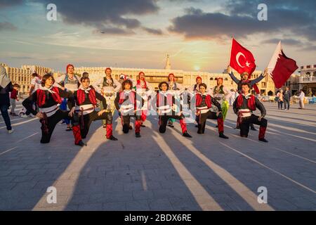 Turkish folklore dance group carrying Qatar and Turkish flags in Souk Waqif, Doha Qatar daylight view with clouds in sky in background Stock Photo