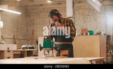 Bearded man worker putting on protective glasses. Mid shot Stock Photo
