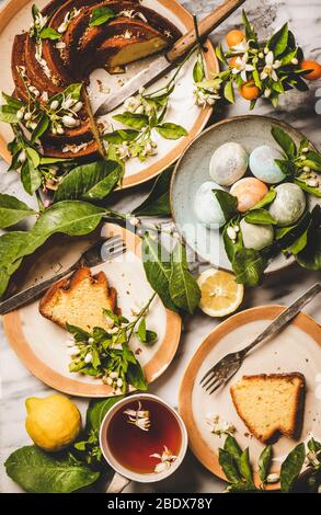 Easter table setting with colorful eggs and citrus cake Stock Photo