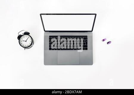 A black-and-white workplace with a laptop, alarm clock. Stock Photo