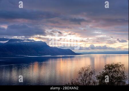 Beautiful sunset over Lake Geneva, Switzerland. Sunlight reflected on the water, dramatic sky in an alpine scene. Stock Photo