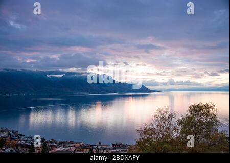 Beautiful sunset over Lake Geneva, Switzerland. Sunlight reflected on the water, dramatic sky in an alpine scene. Stock Photo