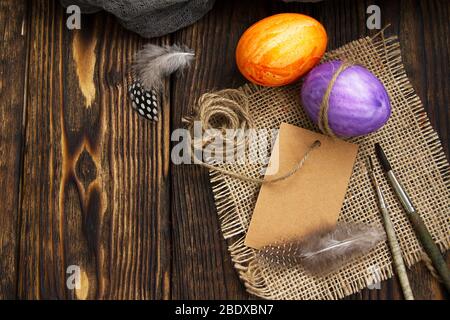 painted two eggs for Easter on a wooden table next to brushes Stock Photo
