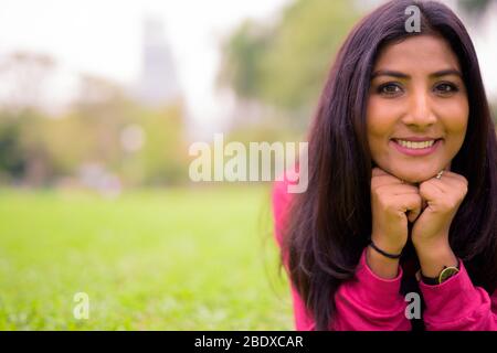 Happy young beautiful Persian woman relaxing at the park Stock Photo
