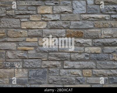 Traditional local stone house wall in Street, Somerset, England. Maybe blue lias. Old. Stock Photo