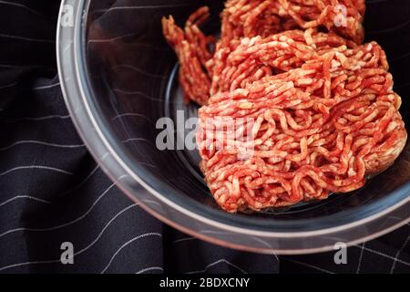 Minced beef in a glass bowl. Low key. Close up. Stock Photo