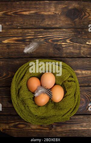 natural eggs in nest woven on wooden background Stock Photo