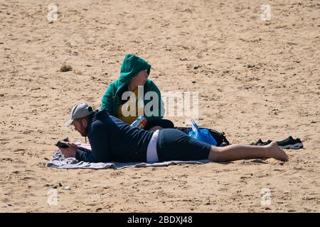 People relax on the beach in Margate, Kent, during the Easter bank holiday weekend, as the UK continues in lockdown to help curb the spread of the coronavirus. Stock Photo