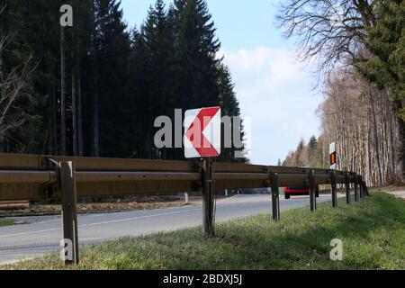 Right Turn Sign: Road signs warn of a sharp turn on a narrow road Stock Photo