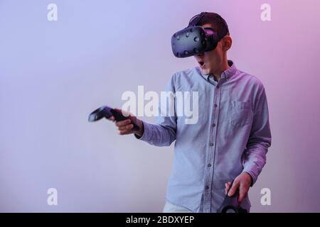 Young man enjoys a game in virtual reality Stock Photo