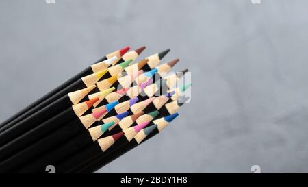 Pencil nibs with black base on gray background. Close up macro shot of color pencil pile Stock Photo