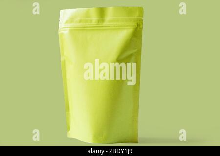 close up of matt green paper doypack stand up packaging pouch with zipper on light green background Stock Photo