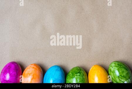 Border of easter eggs in different colors on the bottom on a brown paper background Stock Photo
