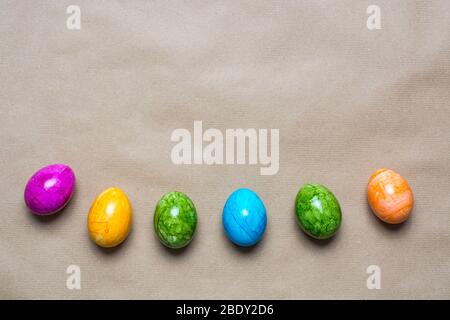 Border of easter eggs in different colors on the bottom on a brown paper background Stock Photo